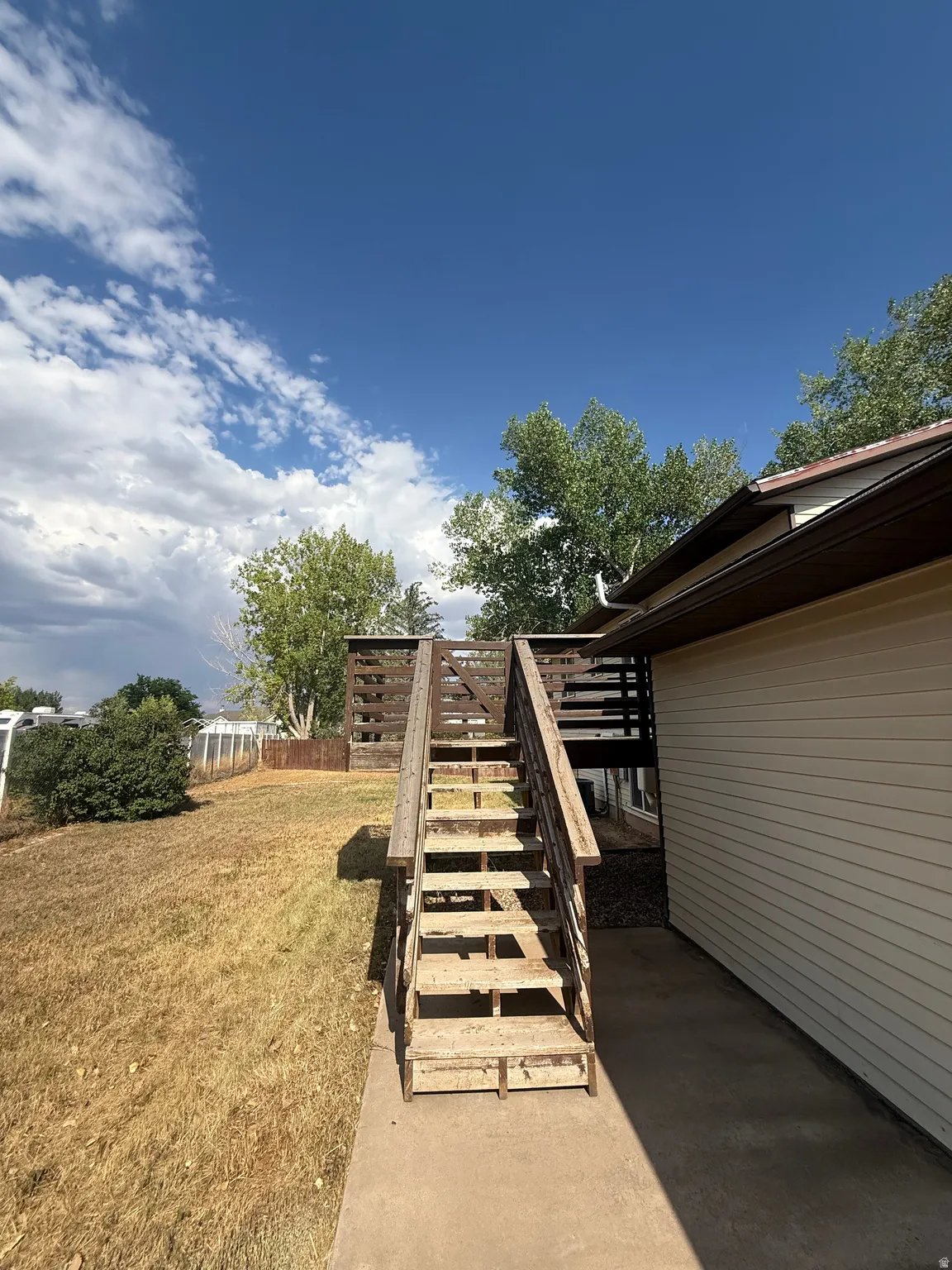 Exterior wood staircase leading to an elevated deck
