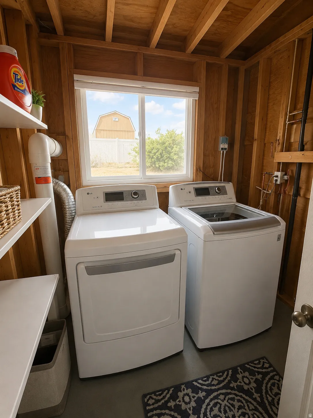 Laundry space featuring exposed wood framing, a full-size window, and built-in shelving
