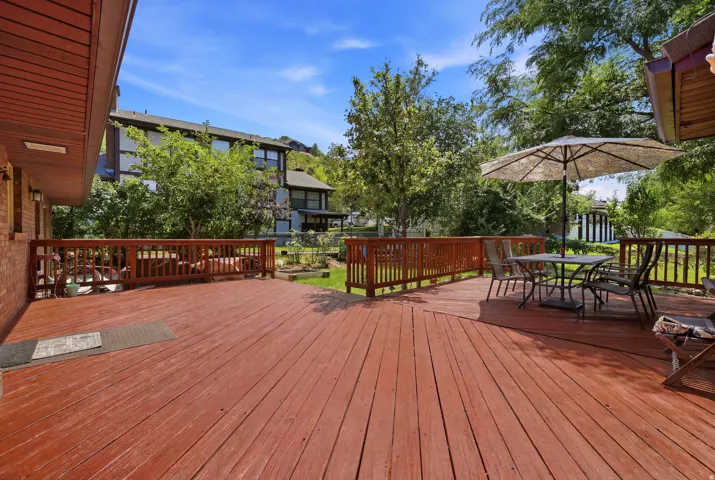 Wood-finish deck with perimeter railings, featuring multiple distinct areas