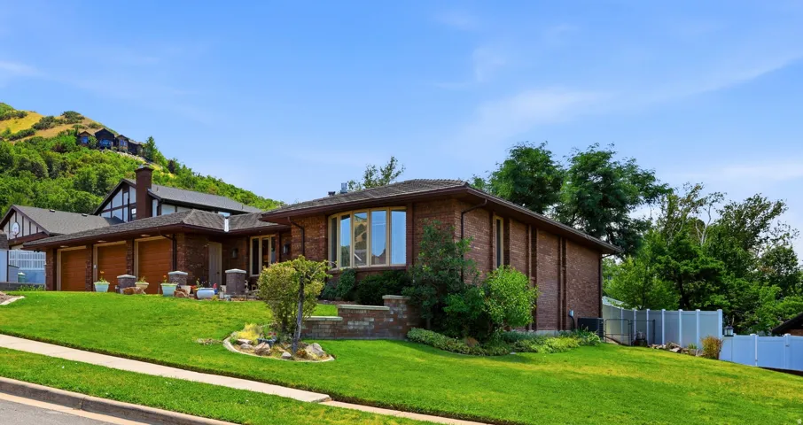 Brick exterior residence with a bay window and multi-car garage