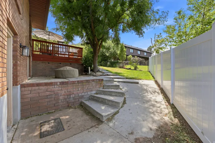 Brick exterior with a raised wooden deck featuring a railing