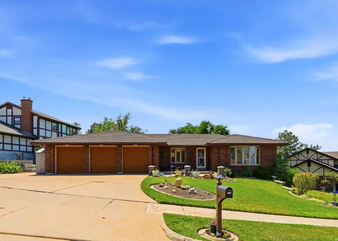 Brick exterior featuring a three-car garage, bay window, and a gabled roof