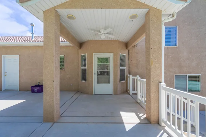 Covered patio featuring a ceiling fan, recessed lighting, white railing, stucco exterior, and a tile roof