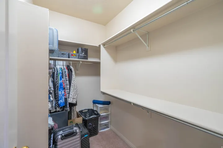 Walk-in closet featuring extensive shelving and hanging rods