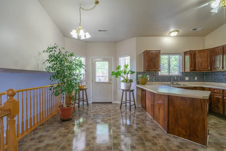 Kitchen with wood cabinetry, light countertops, and mosaic tile backsplash