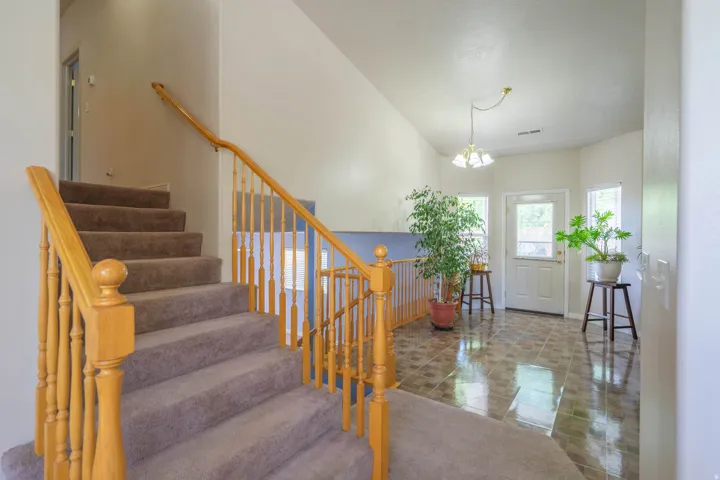 Carpeted staircase with wood banister and spindles