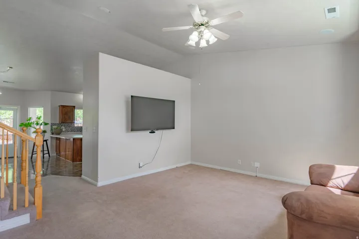 Open-concept living space with carpet flooring and a ceiling fan