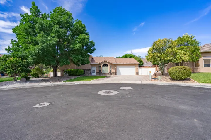 Single-story residence featuring a stucco and stone facade, arched entryway, and an attached two-car garage