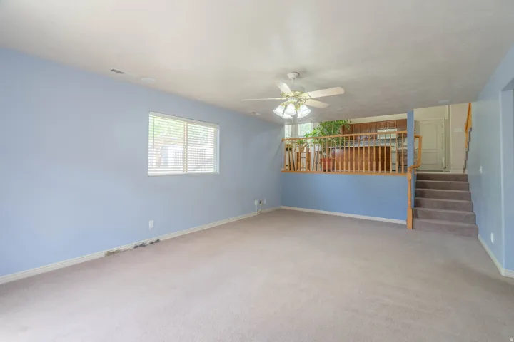 Spacious room featuring light blue walls and neutral carpet flooring