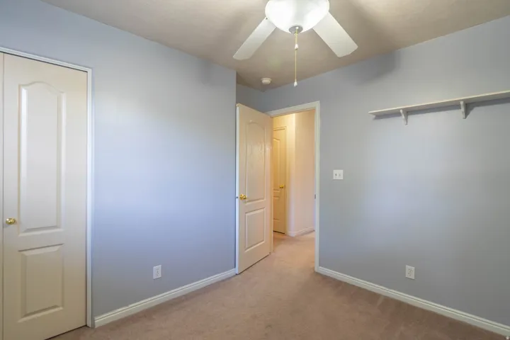 Interior room featuring light blue painted walls, carpeted flooring, and white baseboards