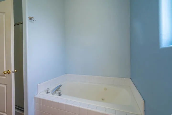 Built-in corner soaking tub with tile surround and deck-mounted chrome fixtures