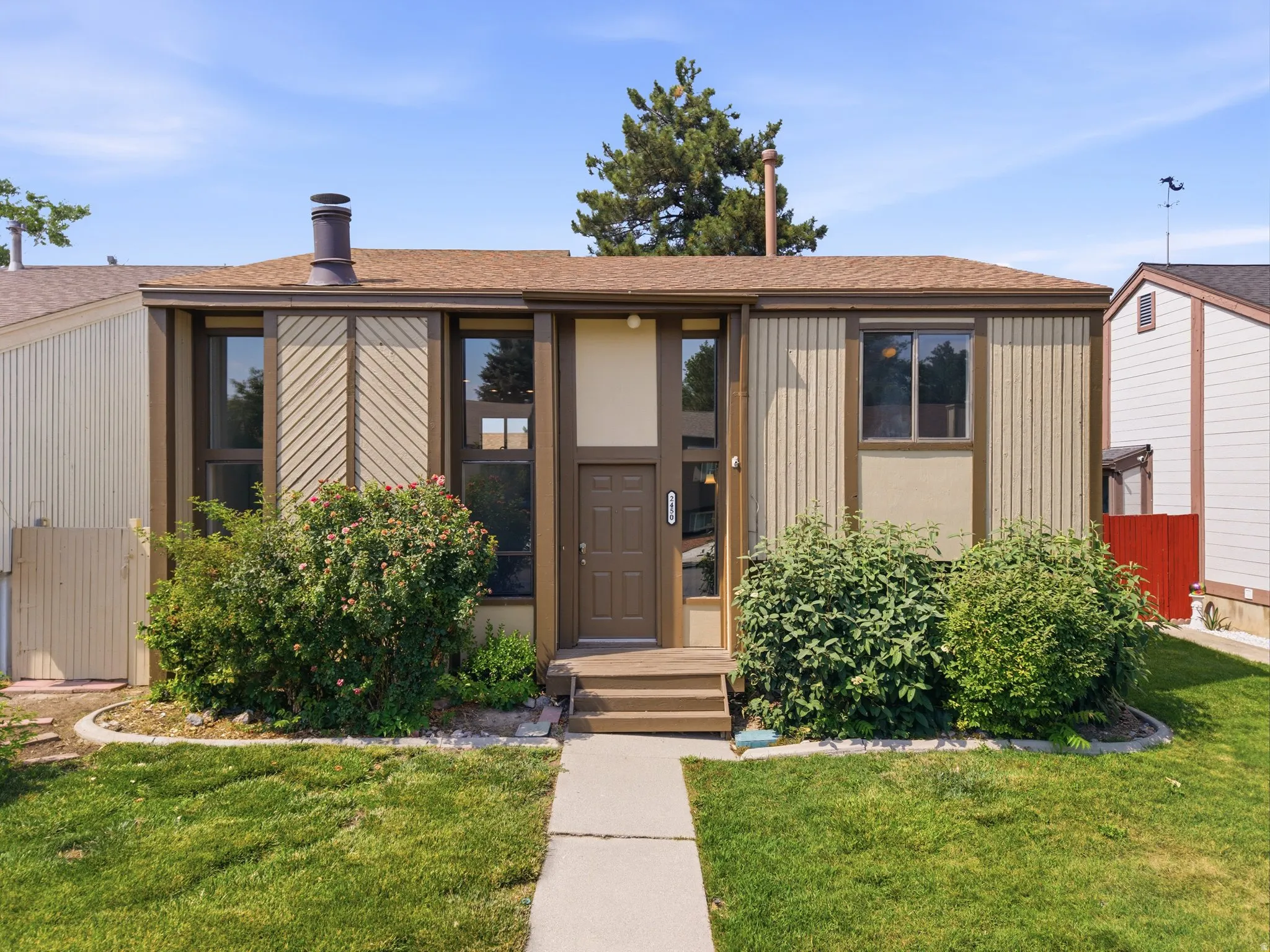 Single-story residence featuring a brown asphalt shingle roof and a matching brown front door