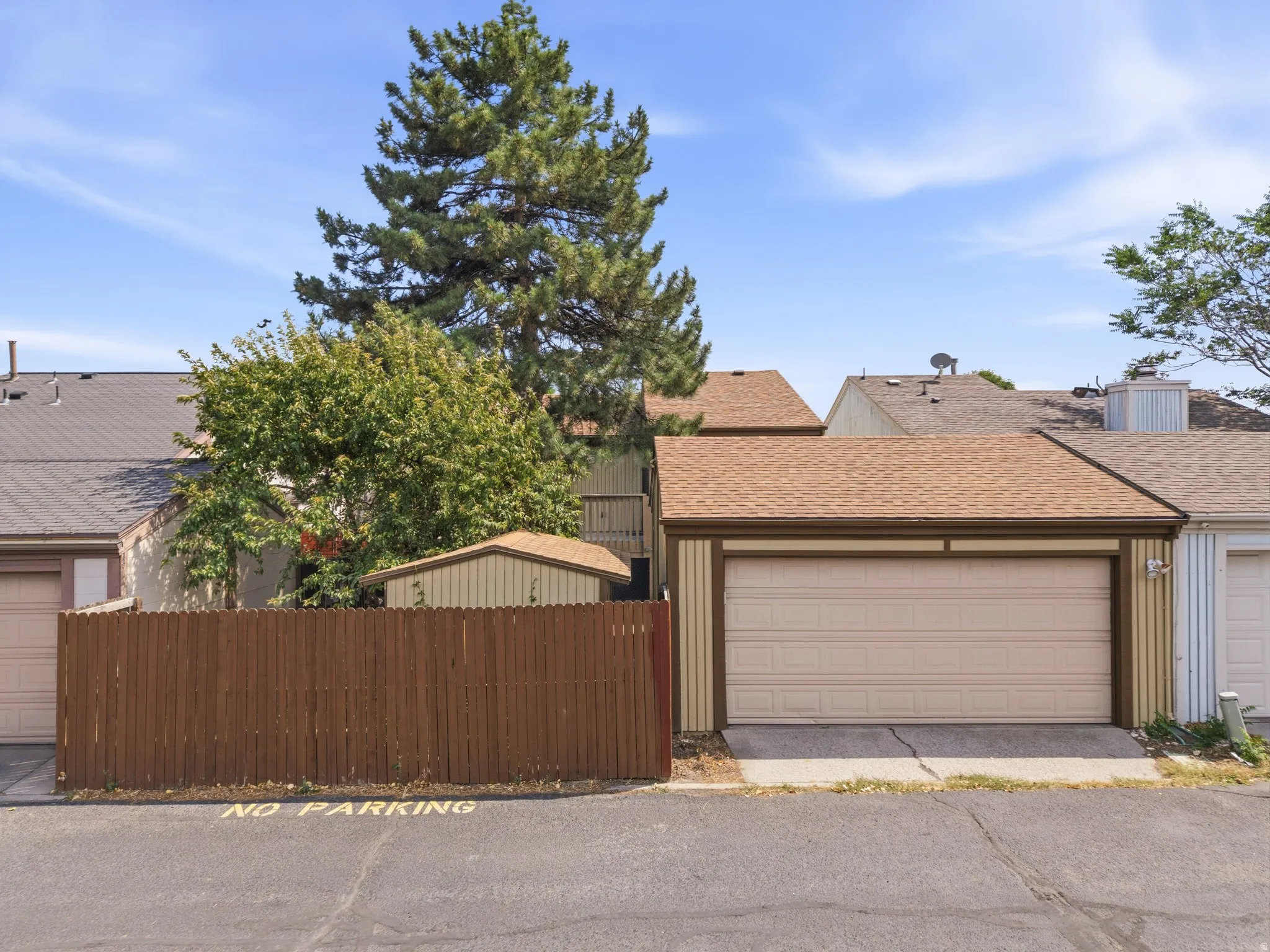 Attached garage with a neutral-toned garage door and shingle roof
