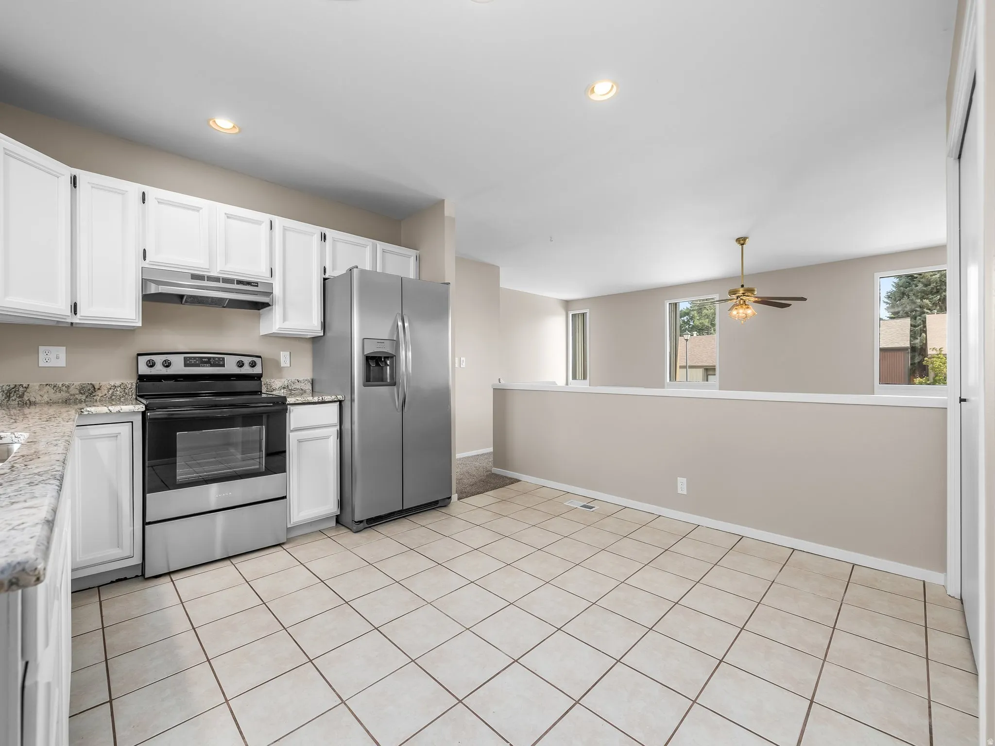 Kitchen featuring white cabinetry, granite-finish countertops, and stainless steel appliances