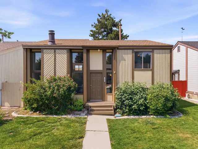 Single-story residence featuring a brown asphalt shingle roof and a matching brown front door