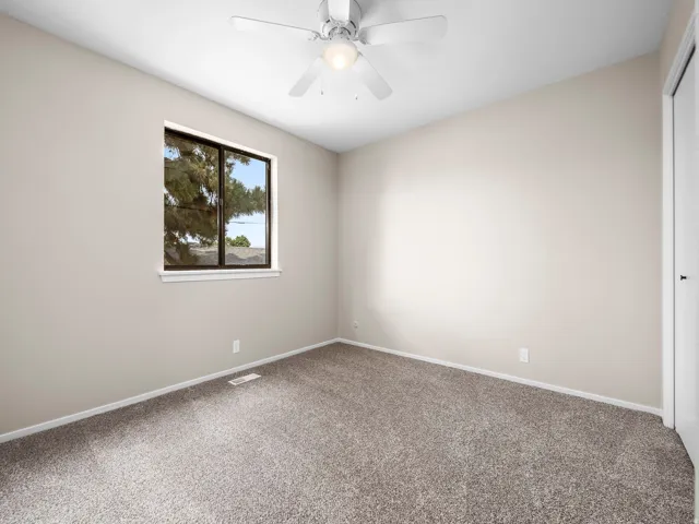 Neutral-toned room featuring a single window with dark framing and a white sill