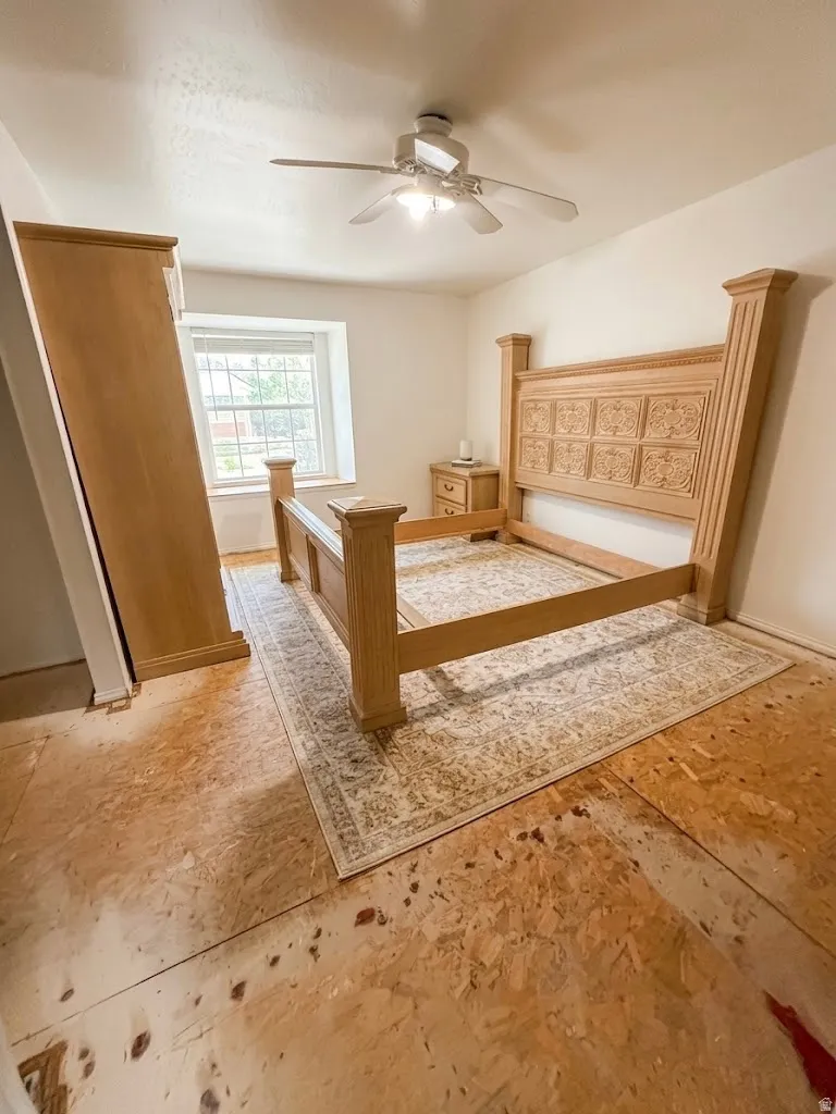 Room featuring a ceiling fan with integrated lighting, a window with exterior grilles, and a light-toned subfloor