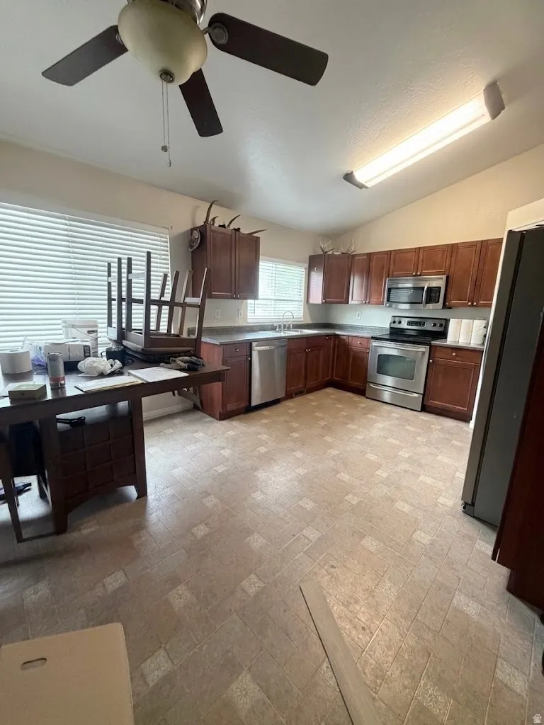 Kitchen featuring wood-finish cabinetry, stainless steel appliances, and ample counter space