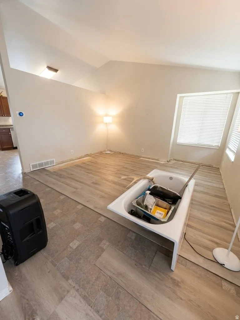 Vaulted ceilings enhance this open concept room featuring wood-finish flooring