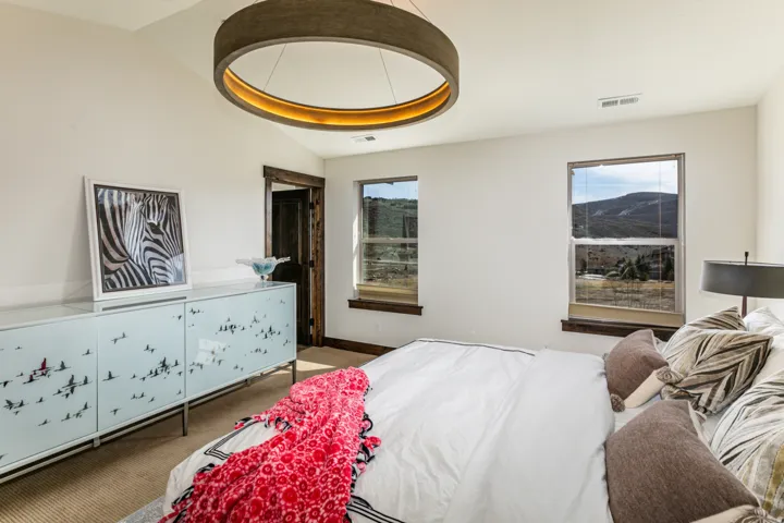 Vaulted ceilings complement two large windows with natural landscape scenery