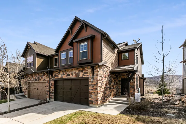 Stone and siding exterior with multiple gables and a multi-car garage