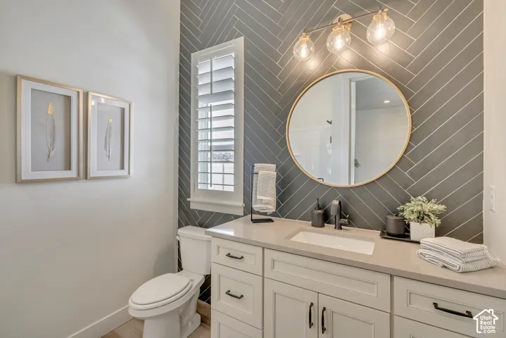 Bathroom featuring a vanity with white cabinetry, a light-toned countertop, and a rectangular undermount sink