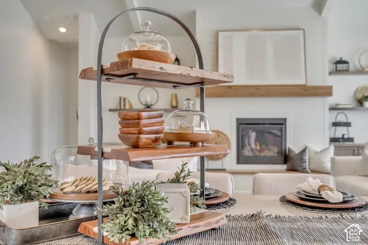 Dining area featuring a fireplace with a wood mantle, shiplap wall, and built-in shelving