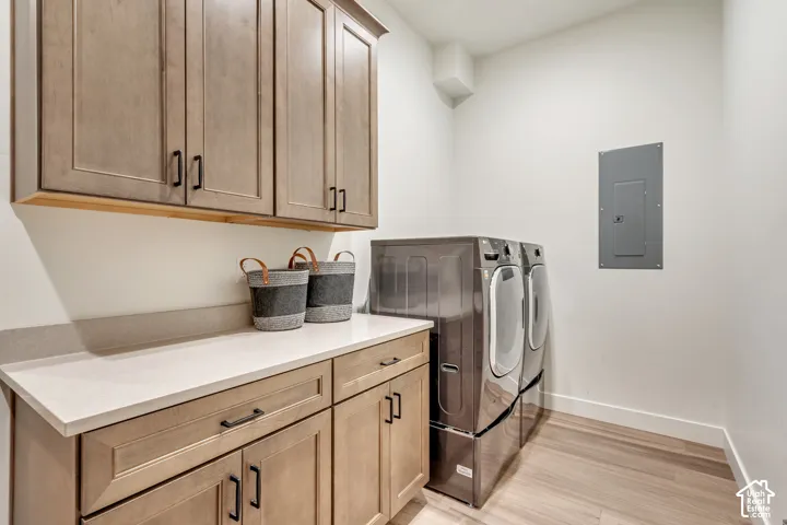 Laundry area featuring built-in wood-finish cabinetry, light-toned countertops, and wood-finish flooring