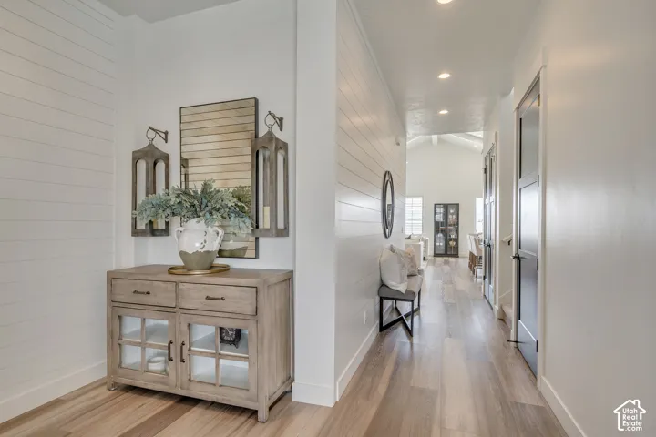 Hallway featuring wood-finish flooring, recessed lighting, and white shiplap wall accents
