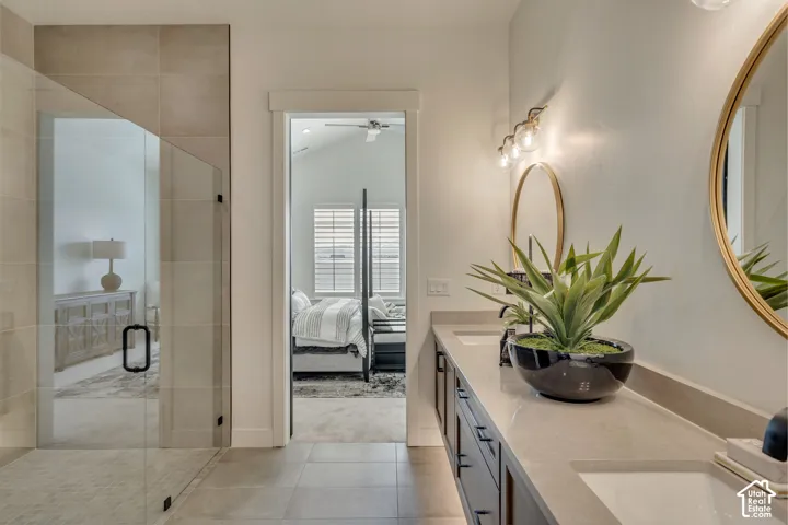 Double vanity with undermount sinks, stone countertops, and dark wood cabinetry