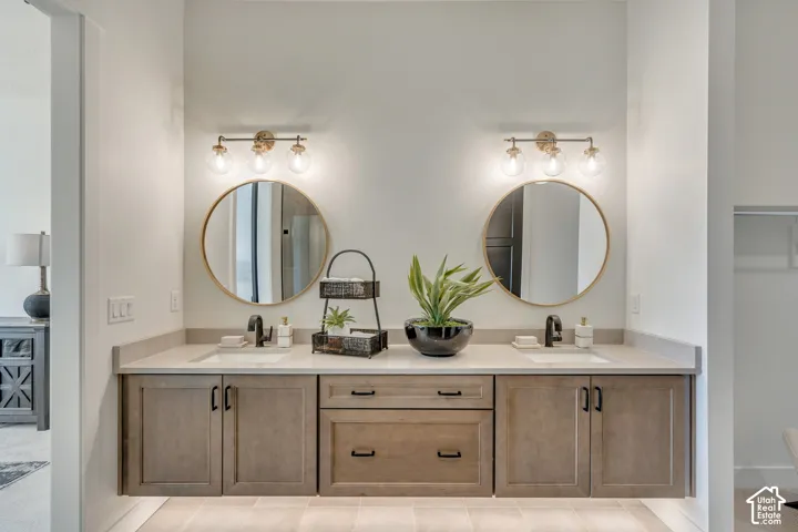 Dual vanity with light wood-finish cabinetry, light-toned countertops, and undermount sinks