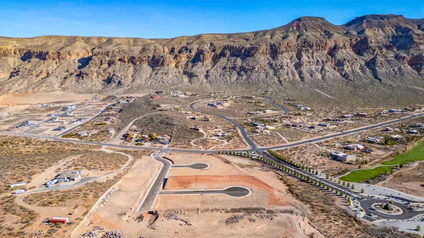 Expansive desert landscape featuring mountain formations and a residential development