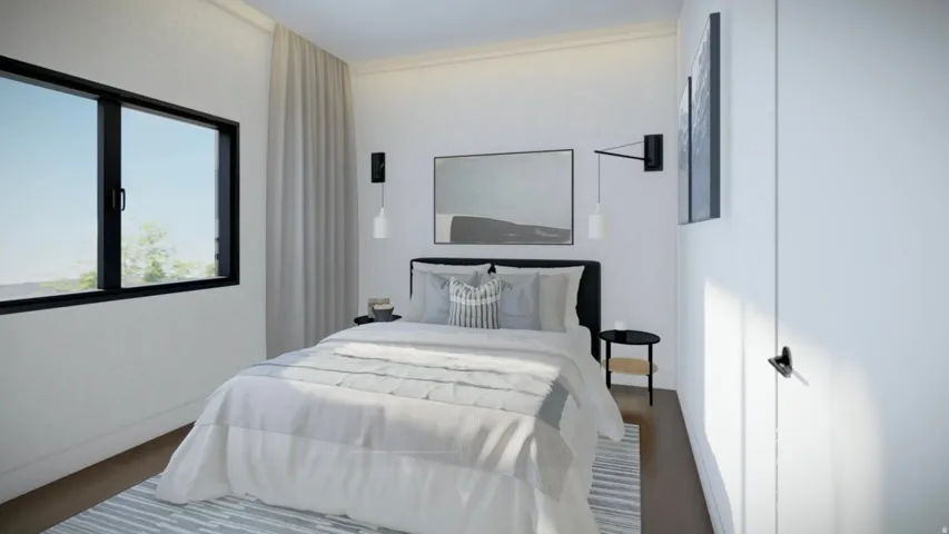 Bright room featuring a large window with black framing, wood-finish flooring, and white walls