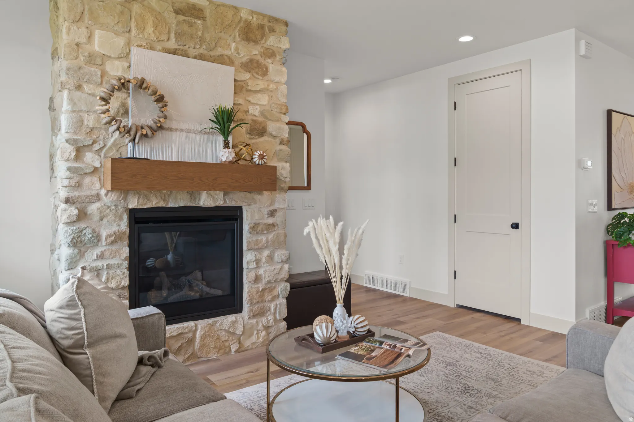 Stone-clad fireplace featuring a wood-finish mantel and a black-framed insert