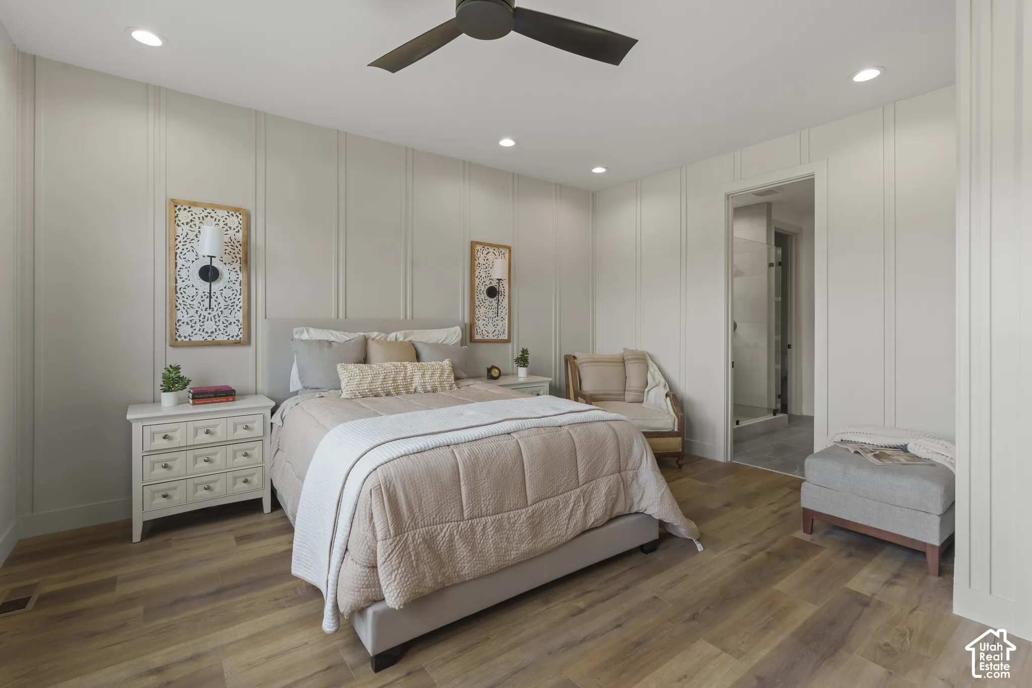Bedroom featuring wood-finish flooring, recessed lighting, a ceiling fan, vertical panel accent walls, and an attached bathroom with a glass-enclosed shower