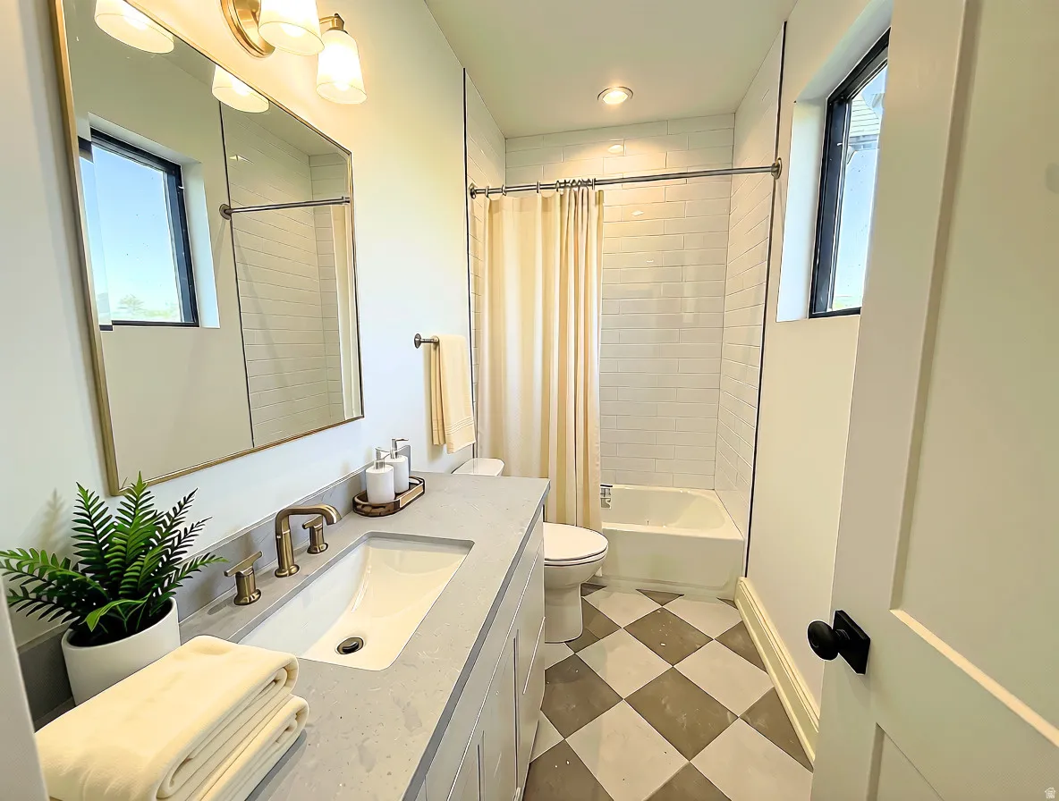 Bathroom featuring a vanity with an integrated sink, a rectangular mirror, and a three-light fixture