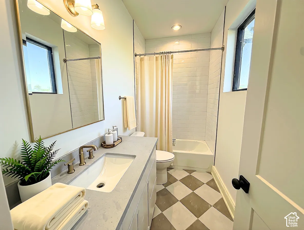 Bathroom featuring a vanity with an integrated sink, a rectangular mirror, and a three-light fixture