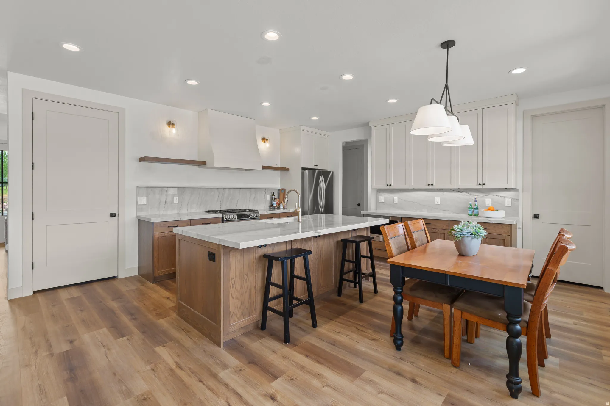 Kitchen featuring wood-finish flooring, recessed lighting, and a center island with counter seating