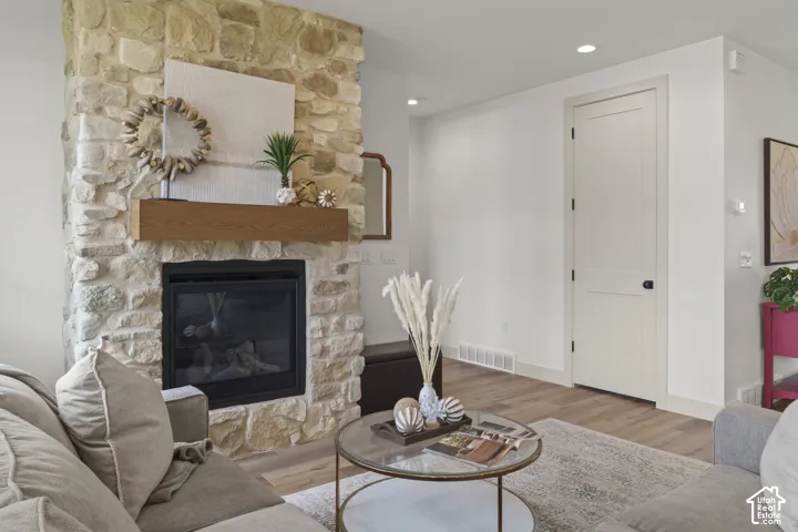 Stone-clad fireplace featuring a wood-finish mantel and a black-framed insert