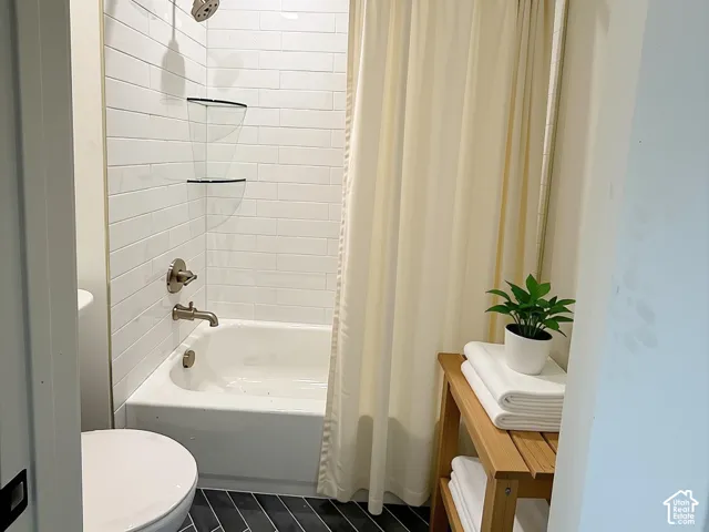 Bathroom featuring a white subway tile surround, recessed lighting, chrome shower fixtures, and dark herringbone floor tiling