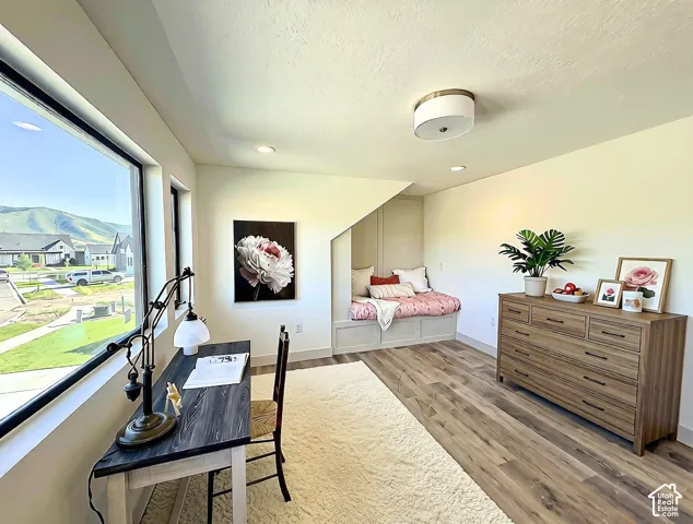 Dedicated room featuring wood-finish flooring, a built-in window seat, large windows, recessed lighting, and a flush mount ceiling fixture