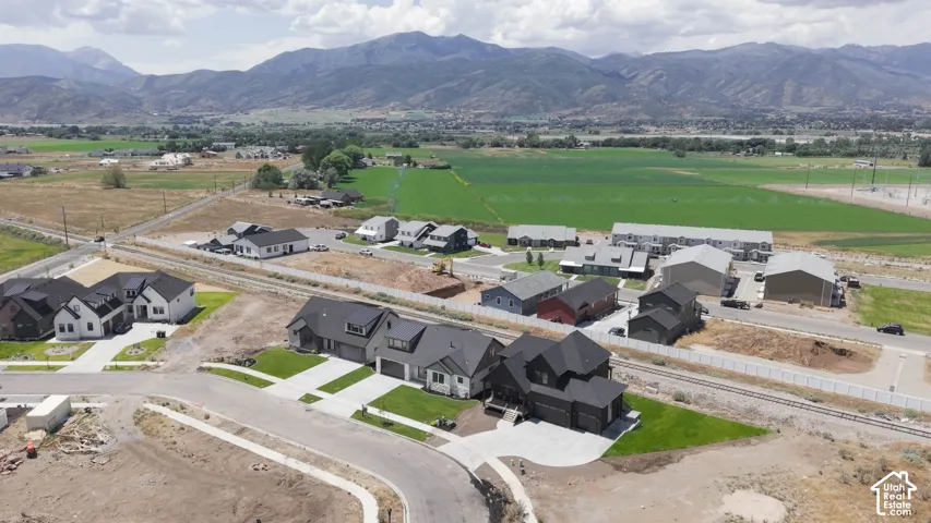 Aerial perspective showcasing a developing residential area with modern homes and mountain scenery