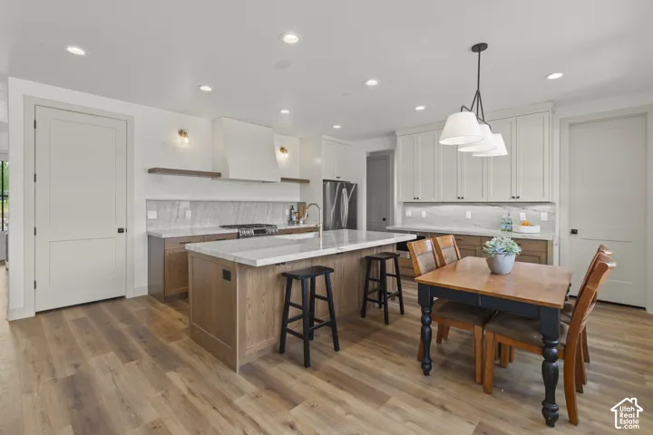Kitchen featuring wood-finish flooring, recessed lighting, and a center island with counter seating