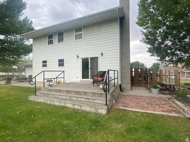 Rear exterior of residence featuring white siding and deck off the family room area.