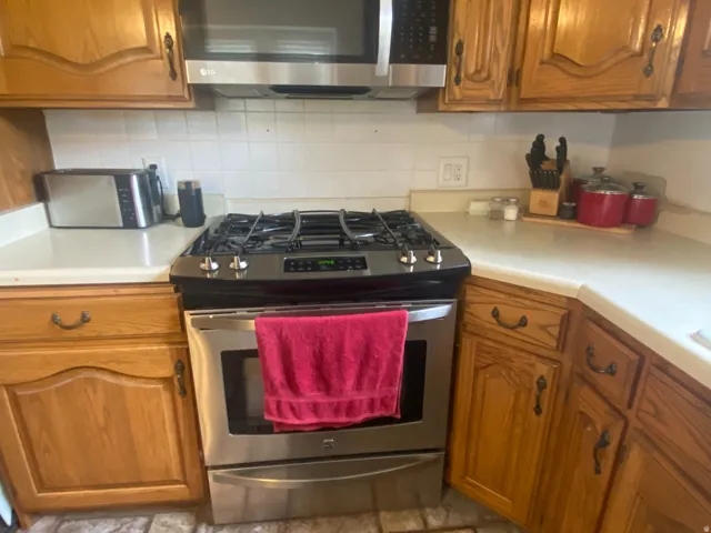 Kitchen featuring stainless steel gas range and coordinating over-the-range microwave