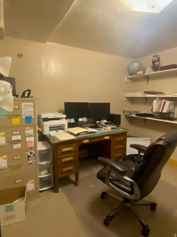 Dedicated room featuring recessed ceiling lighting, wall-mounted shelving, and neutral wall tones