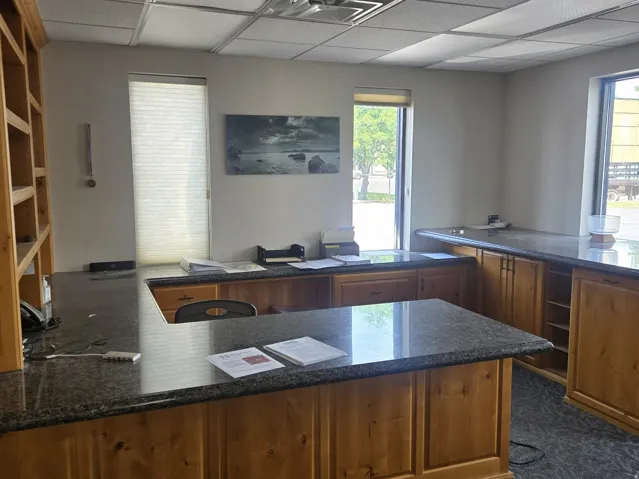 Large Office space featuring built-in wood cabinetry with stone-finish countertops