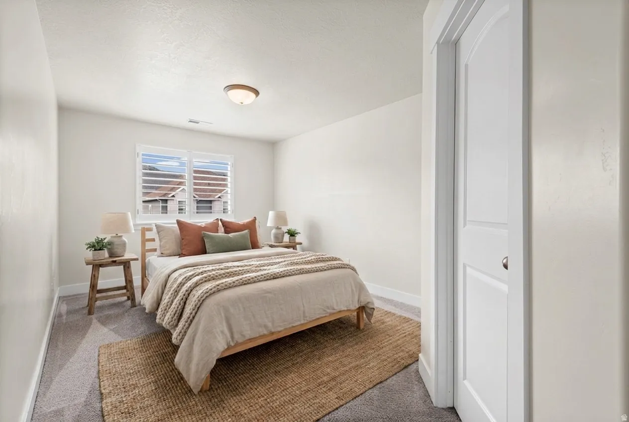 Bright room with neutral wall tones and grey carpeting. Virtually staged.