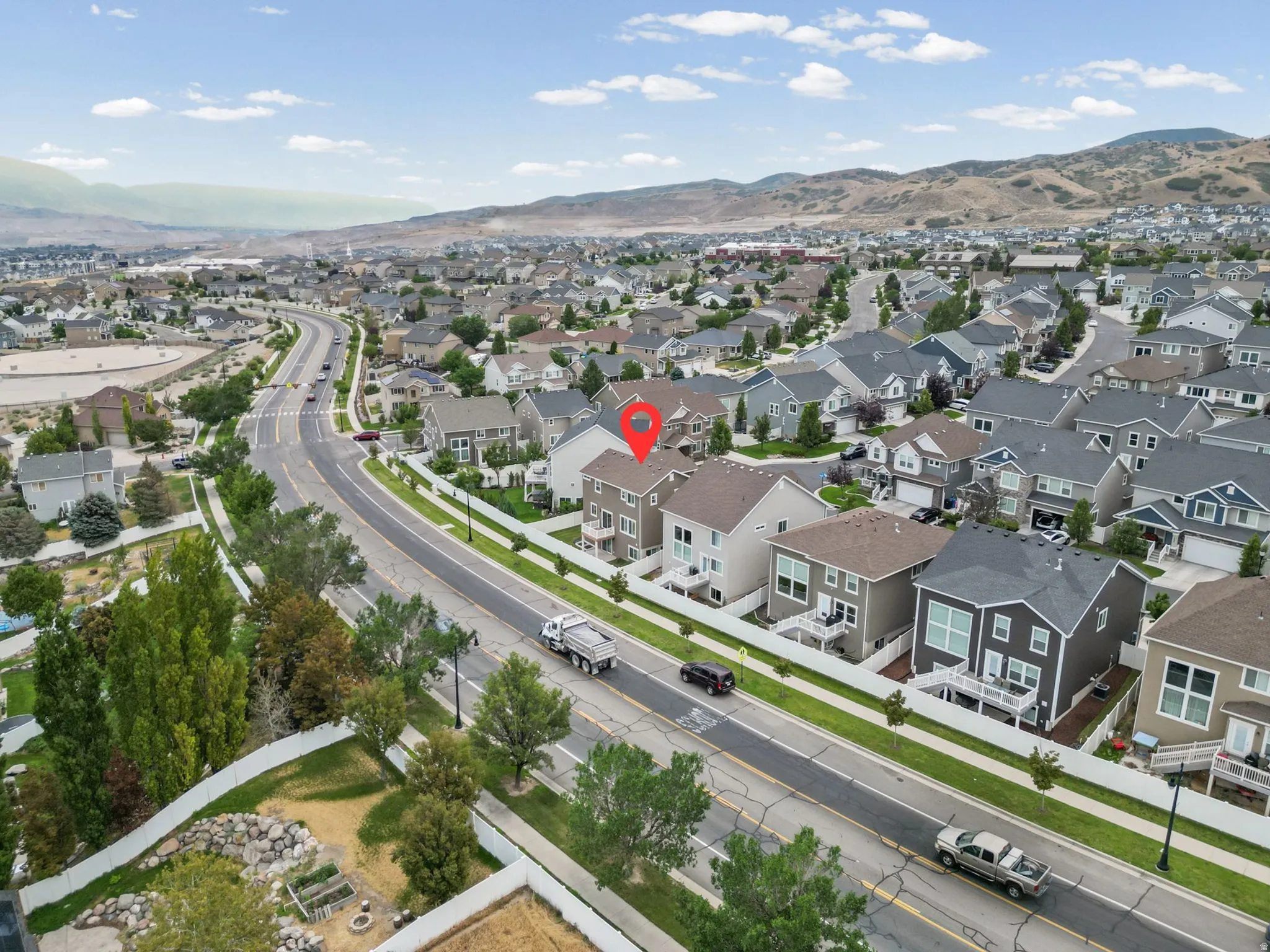 Aerial perspective highlighting a residential property with a light-colored exterior and a multi-level design