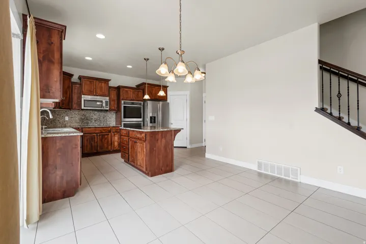 Expansive kitchen with rich wood cabinetry, stainless steel appliances, and a central island